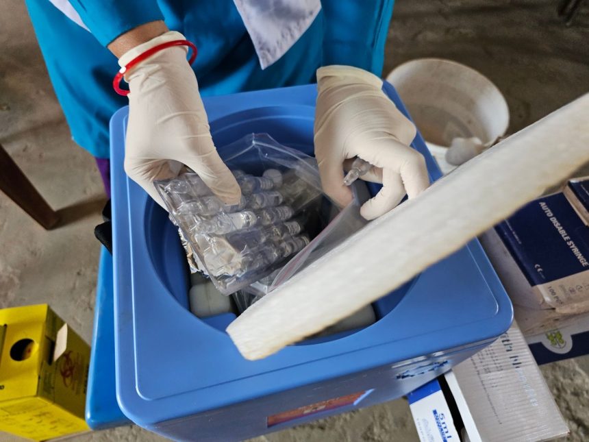 Profissional usando luvas manipula frascos em um laboratório.